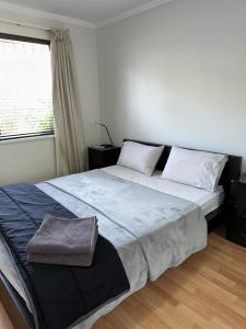 a large bed in a bedroom with a window at Parkline Apartments Perth in Perth