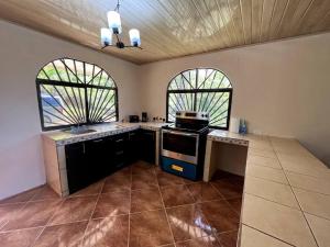 a kitchen with two windows and a stove top oven at Mountain Breeze Villa 