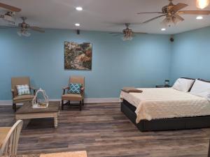 a bedroom with blue walls and a bed and two chairs at Cozy studio with movie theater, beach 5 min away in Morehead City