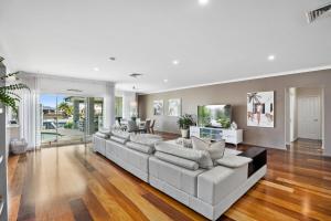 a large living room with a couch and a tv at SEACLUSION 5 bed waterfront, sleeps 12 in Gold Coast