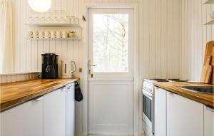 uma cozinha com armários brancos e uma porta branca em Awesome Home In Nex With Kitchen em Vester Sømarken