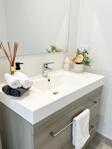 a bathroom with a white sink and a mirror at Luxury 2 Bedroom Apartment with cocktail bar and espresso machine in Auckland