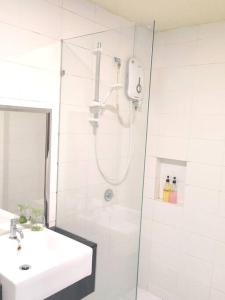 a white bathroom with a shower and a sink at ANS Homestay Trefoil setia alam in Shah Alam