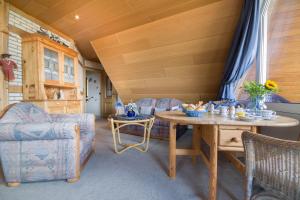 una sala de estar con una mesa y sillas en Meeresbrandung FeWo 36, en Cuxhaven 11 fotos más