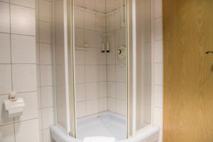 una ducha con puerta de cristal en un baño en Meeresbrandung FeWo 36, en Cuxhaven