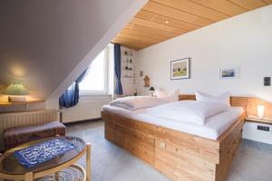 Un dormitorio con una cama grande y una mesa. en Meeresbrandung FeWo 36, en Cuxhaven