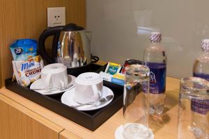 a tray with cups and saucers on top of a table at Starcity Hotel & Condotel Beachfront Nha Trang in Nha Trang