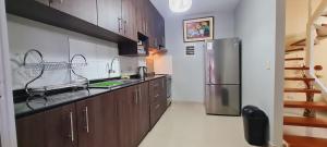 a kitchen with wooden cabinets and a stainless steel refrigerator at CASA VIP PIURA, piscina privada, full amoblada in Piura