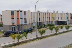 a row of buildings with palm trees in front of a street at CASA VIP PIURA, piscina privada, full amoblada in Piura