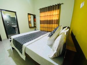 a bedroom with a large bed with a mirror at Crown Resort in Nuwara Eliya