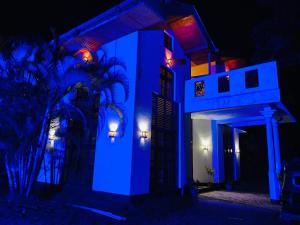 a house lit up in blue at night at Crown Resort in Nuwara Eliya