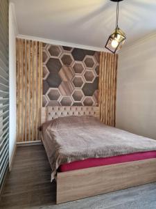 1 dormitorio con 1 cama con pared de piedra en Stail en Bălţi