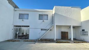 a white building with a staircase in front of it at Habitacion Privada Ejecutiva Minisplit Amenidades 2 in Castillo Teresa