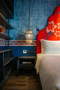 a bedroom with a bed with a red head board at SMARANA Hanoi HERITAGE in Hanoi