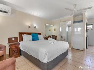 a bedroom with a large bed and a living room at Studio 3 ENDEAVOUR INN in Emu Park