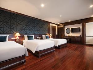 um quarto de hotel com duas camas e uma televisão de ecrã plano em Aqua Of The Seas Cruise Halong em Ha Long