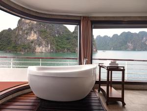 a bath tub in a room with a large window at Aqua Of The Seas Cruise Halong in Ha Long