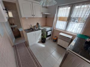 a small kitchen with white cabinets and a sink at Dizike Pet-friendly Guesthouse in Budapest +2 photos