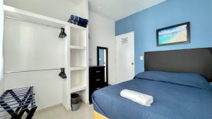 a bedroom with a bed and a blue wall at Habitacion Privada Ejecutiva Confortable Minisplit Amenidades 1 in Castillo Teresa