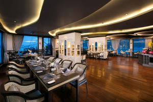 a dining room with tables and chairs and the ocean at Lapinta Luxury Cruises in Ha Long