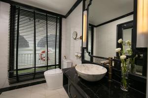 a bathroom with a sink and a toilet and a window at Lapinta Luxury Cruises in Ha Long