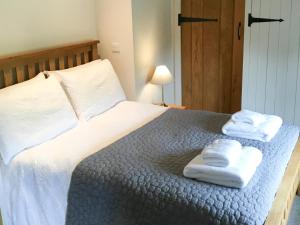 a bedroom with a bed with two towels on it at Crabapple Cottage in Llanyblodwel