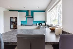 a kitchen with a large table with two chairs at Ty Llewelyn in Twdweiliog