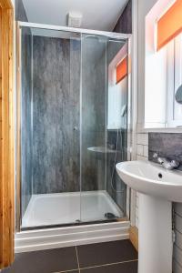 a bathroom with a shower and a sink at Ty Llewelyn in Twdweiliog
