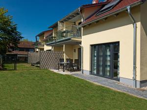 ein Haus mit einer Terrasse und einem Balkon mit einem Tisch in der Unterkunft Gollwitzer Ferienidyll A07 19c Sturmmöwe in Gollwitz