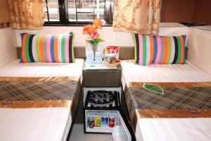 a room with two beds and a vase with flowers at London Guest House in Hong Kong