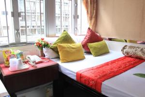 a hotel room with two beds with colorful pillows at London Guest House in Hong Kong