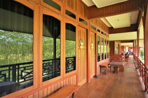 eine Veranda eines Gebäudes mit Bänken und Fenstern in der Unterkunft Kasuari Exotic Resort Magelang in Magelang