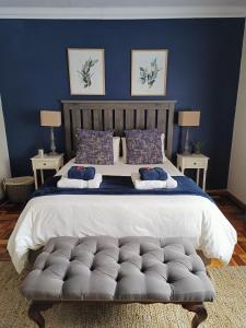 um quarto com uma cama grande e uma parede azul em LemonBlossom em Bloemfontein