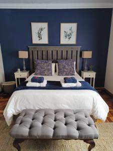 a bedroom with a large bed with a blue wall at LemonBlossom in Bloemfontein