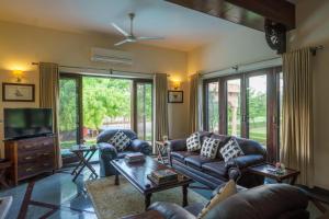 un salon avec un canapé et une télévision dans l'établissement amã Stays & Trails Abhay Villa Bisalpur, Jodhpur, à Jodhpur