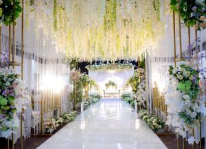 a wedding aisle with white flowers and lights at Manise Hotel in Ambon