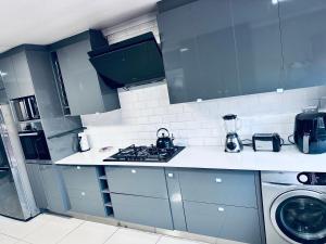 a kitchen with a stove and a washing machine at Private 3-bed Unit in Johannesburg with Power Backup in Roodepoort