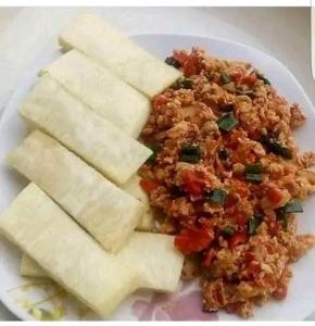 a white plate of food with rice and tofu at Palazzo Apartments in Ikeja