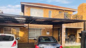 a car parked in front of a house with a pergola at Private 3-bed Unit in Johannesburg with Power Backup in Roodepoort
