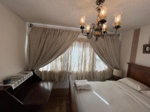 a bedroom with a bed and a chandelier and a window at Elle’s house in San Rafael