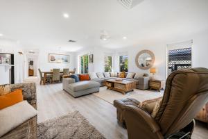 a living room with a couch and a table at Kailani Beach House - LJHooker Yamba in Yamba