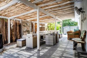 a living room with a pergola with a table and chairs at Kailani Beach House - LJHooker Yamba in Yamba