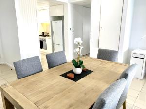 a wooden table with chairs and a vase with flowers on it at Serenity Deja Blue - at Darwin Waterfront in Darwin