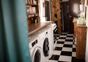 a washing machine in a kitchen with a checkered floor at Libling Štiavnický in Banská Štiavnica