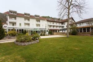 ein großes weißes Gebäude mit einem grünen Hof in der Unterkunft Hotel Kurparkblick in Bad Bergzabern