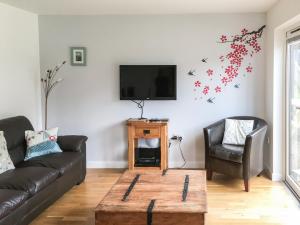 a living room with a couch and a tv at Porhellik in Zelah