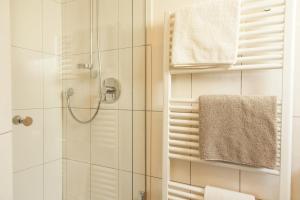 a bathroom with a shower and a toilet and towels at Haus Sonneneck - ski in & out in Sankt Anton am Arlberg +25 photos