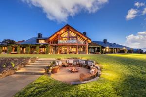 a large house with a fire pit in the yard at Spicers Peak Lodge in Maryvale