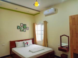 a bedroom with a bed and a mirror and a window at Đức Chính Hotel - Ninh Chu - Phan Rang in Phan Rang