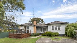 a white house with a deck in the yard at Nelson By The Bay in Apollo Bay